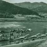 Lotnisko w Kurowie ok. 1960 r.  Widać trzy dwupłatowce CSS-13, trzy Muchy 100, Muchę Standard i dwuosobową szkolną Czaplę. Z "rzutu kołowego" widać bagażówkę Nysa-59 i ciągnik Zetor 25 "Bocian". Zniszczona nawierzchnia lotniska to skutek zalania wodą pobliskiego Dunajca.